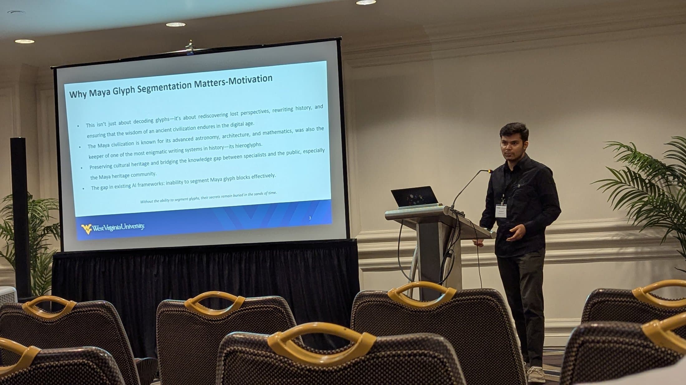 Shivam presenting a slide titled 'Why Maya Glyph Segmentation Matters' at a conference podium.